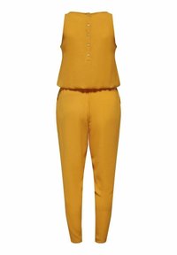 Jumpsuit jaune moutarde avec un haut sans manches, fermeture à boutons au dos et pantalons fuselés, mettant en avant un tissu lisse et texturé.