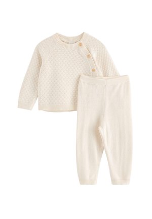 Maglioncino per neonato color crema lavorato a maglia con tre bottoni di legno sulla spalla, abbinato a pantaloni in maglia coordinati.