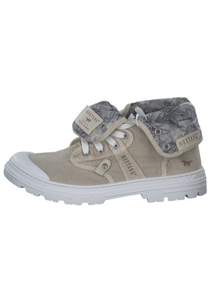 Bottines en daim beige avec un col doublé de motifs floraux gris, semelle en caoutchouc blanche et accent de marque. Elles présentent un système de laçage et une languette sur le côté.