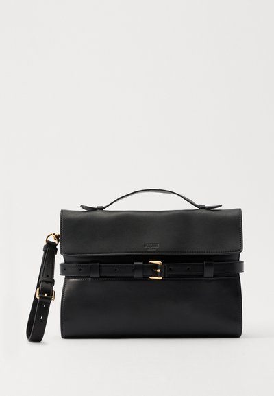 Sac à main en cuir noir avec un rabat repliable, une bandoulière réglable et des finitions en métal doré. Présente un détail ceinture et une texture lisse.