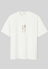 T-shirt en coton blanc présentant un graphique central avec des icônes, y compris un arbre, un sac à dos, une lanterne et un élément de texte "WILDLIFE".