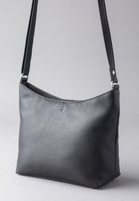 Black leather shoulder bag with a textured finish, featuring a curved top, zip closure, and an adjustable strap. Subtle logo detail on the front.