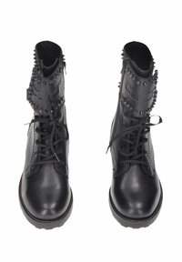 Stivali da combattimento in pelle nera presentano una caviglia alta, punte sporgenti attorno al colletto, lacci e suole testurizzate con cuciture decorative.