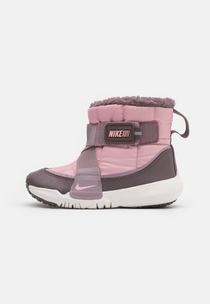 Botte d'hiver isolée Nike rose et violette avec semelle blanche, bride velcro et doublure douce conçue pour temps froid.