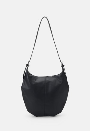 Sac à épaule en cuir noir avec une longue bandoulière réglable et une fermeture éclair sur le dessus, présenté sur un fond gris clair.