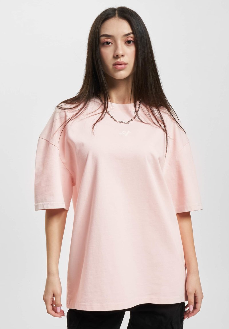 Lys pink oversized t-shirt lavet af blød bomuld, med korte ærmer, rund hals og en lille logo detalje på brystet.