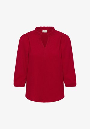 Red blouse with a ruffled neckline, three-quarter puff sleeves, and a V-shaped opening. Textured fabric with a smooth finish.