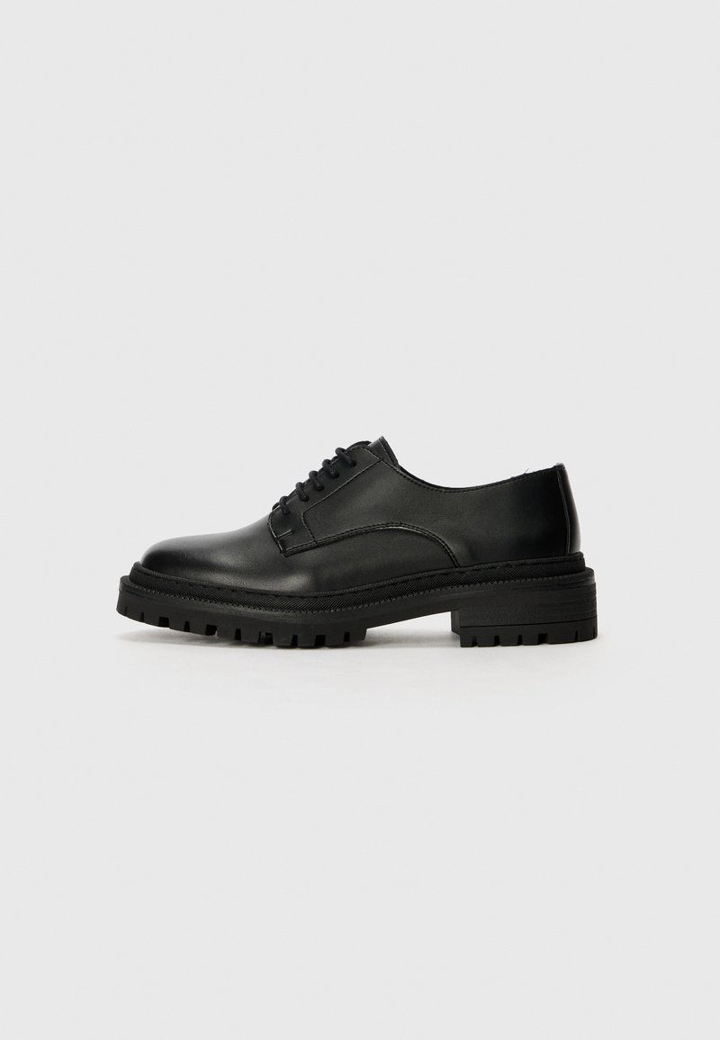 Zwarte leren oxford schoen met een ronde neus, vetersluiting en een gestructureerde rubberen zool met profiel voor grip.