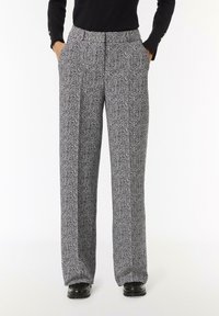 Weite Hosen mit einem schwarz-weißen Fischgrätenmuster, hoch tailliert und mit Seitentaschen, aus einem glatten, strukturierten Stoff.
