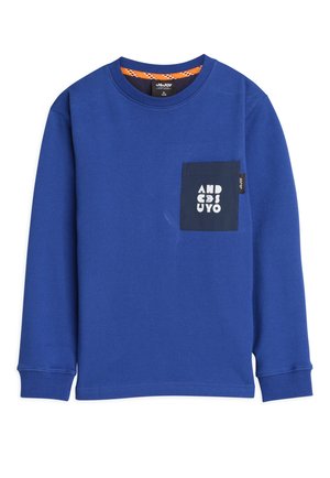 T-shirt bleu à manches longues en coton, avec une poche marine et des lettres blanches. Encolure ronde et poignets cousus.