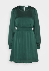 Grön långärmad klänning i mjukt tyg med rund halsringning, inskuren midja och nyckelhålsdetalj i ryggen. Texturerade ärmar och fåll.