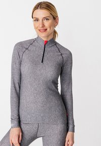 Graues langärmliges Sportoberteil mit halber Reißverschlussöffnung, kontrastierendem roten Akzent und strukturiertem Stoff. Verfügt über eine figurbetonte Passform und Logodetails an den Bündchen.