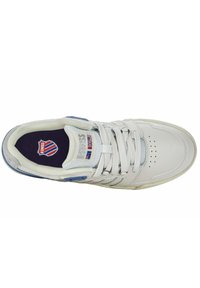 Scarpa sportiva bianca con accenti blu, tomaia in pelle texturizzata, linguetta in rete, punta perforata e chiusura con lacci. Presenta un logo sulla soletta.