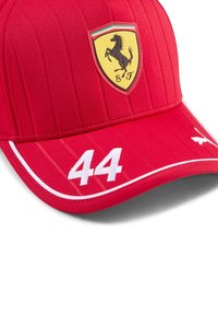 Red cap with vertical ribbed texture, featuring a black prancing horse emblem on a yellow shield and the number "44" in white on the visor.