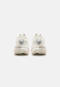 Weiße Sportschuhe mit strukturiertem Obermaterial, abgerundeter Ferse und grau gestalteten Akzenten. Verfügt über eine Ziehlasch und eine vielfältig gemusterte Sohle.