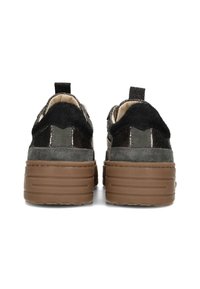Turnschuhe mit schwarzem Fell und glänzender Textur, mit einer dicken braunen Sohle, von hinten präsentiert, um das Schuhdesign hervorzuheben.