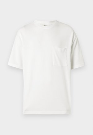 Maglietta bianca in cotone con scollo rotondo, maniche corte e taschino sul petto sinistro. Tessuto liscio, vestibilità regolare, senza motivi o decorazioni.