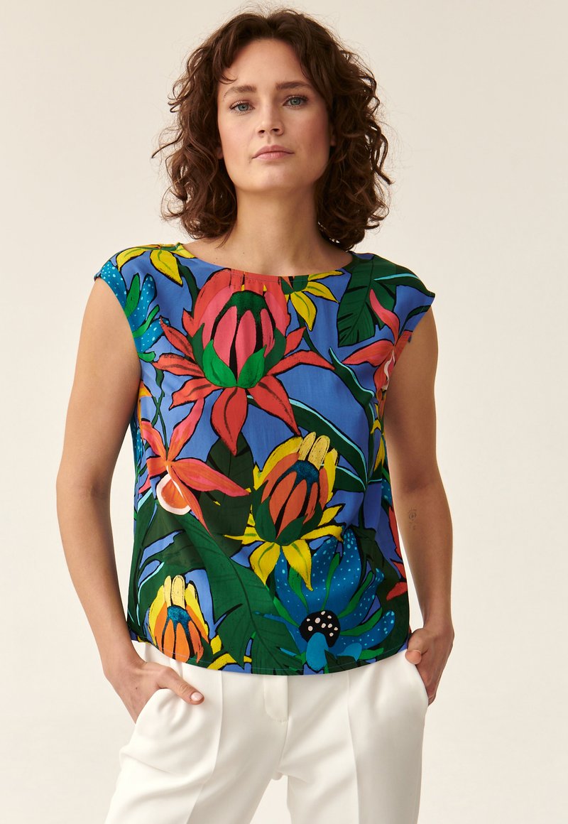 Ärmelloses Blumenoberteil mit einem blauen Hintergrund und großen roten, gelben und grünen Blumenmustern; weicher Stoff mit lockerer Passform.