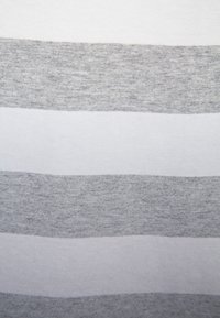 Grå och vit randig tyg med en mjuk textur; växlande horisontella band i ljusgrått och vitt, med en slät yta.