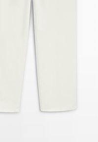 Białe spodnie o prostych nogawkach wykonane z bawełnianej tkaniny mieszanej. Charakteryzują się gładką fakturą, czystymi liniami i standardowym szwem bez widocznych elementów metalowych.