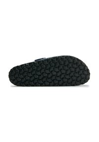 Black rubber sole with a textured pattern, featuring raised circular shapes. The shape is flat with a slight curve at the heel.