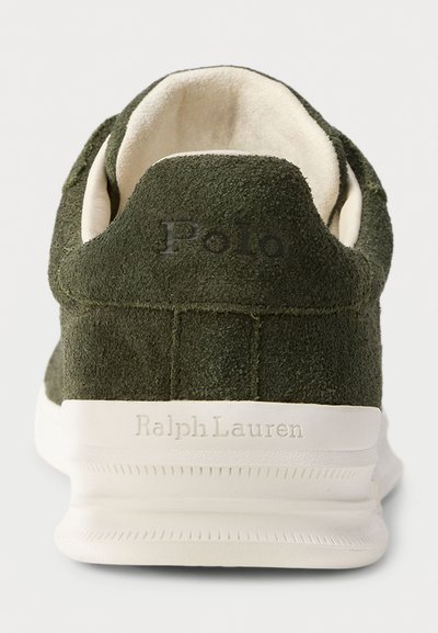 Călcâiul sneaker-ului verde din suede are inscripționat "Polo" pe spate și "Ralph Lauren" pe talpa albă.