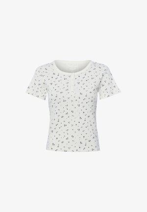 Haut blanc à manches courtes côtelé avec un petit imprimé floral noir et un col rond avec trois boutons au centre avant.