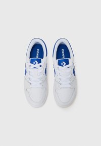 Baskets blanches avec des accents bleus, en cuir lisse, bout rond et design classique à lacets avec logo sur la languette.