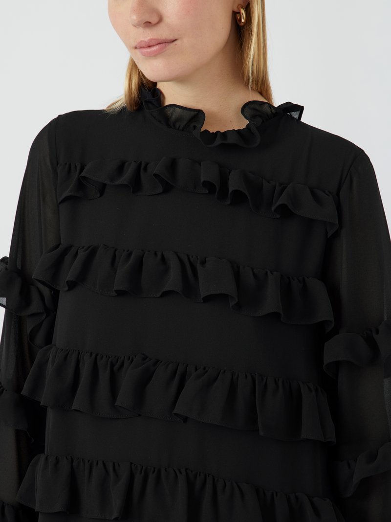 Schwarze Bluse mit geschichteten Rüschen an der Vorderseite und an den Ärmeln. Hergestellt aus leichtem Stoff mit einem rüschenbesetzten Rundhalsausschnitt und langen Ärmeln.