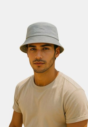 Gray bucket hat made of soft fabric with a wide brim, paired with a plain beige t-shirt. Texture appears smooth, featuring no visible patterns.
