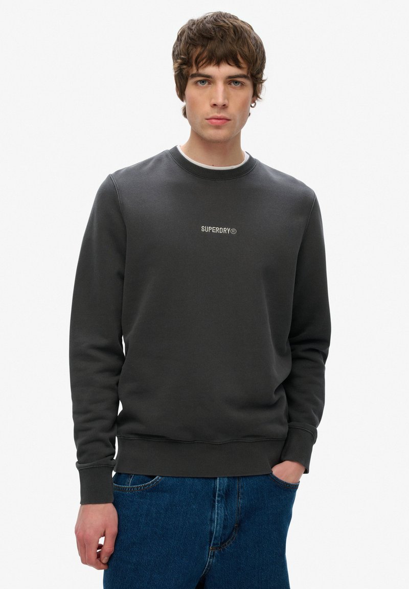 Mørkegrå crewneck sweatshirt lavet af blød bomuldsblanding, med ribbede manchetter og kant, samt et subtilt hvidt "SUPERDRY" logo på brystet.