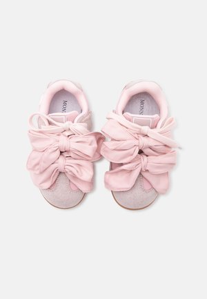 Paire de baskets rose clair avec de grands nœuds en tissu noués sur le dessus, en daim doux avec intérieur rembourré.