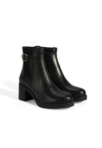 Schwarze Leder-Stiefeletten mit glatter Oberfläche, seitlichen elastischen Einsätzen und einer goldfarbenen Schnallenakzentuierung. Blockabsatz für Stabilität.