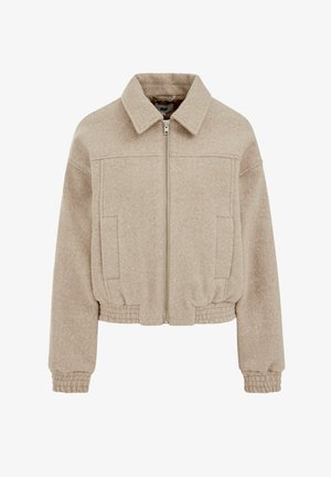 Bež krojena jakna od teksturiranog tkanja, s prednjim patentnim zatvaračem, dva bočna džepa i elastičnim manšetama i rubom.