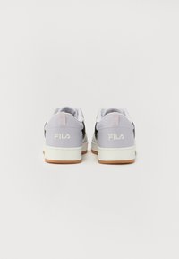 Lilla og svarte joggesko med en hvit såle, med en baklogo og en teksturert overflate, designet med en lavprofil silhuett.