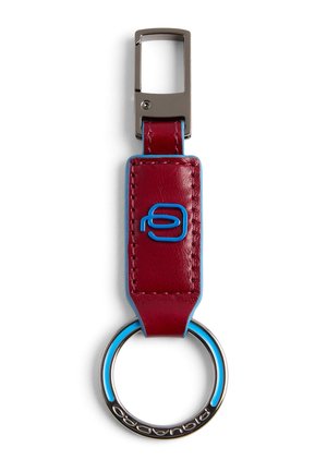 Porte-clés en cuir rouge avec coutures bleues et logo, anneau en métal avec accents bleus, et attache à clip rectangulaire argenté.