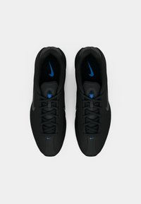 Μαύρα αθλητικά παπούτσια με υφή στο πάνω μέρος, διαθέτουν μαύρα κορδόνια, μπλε λογότυπο Nike στη γλώσσα και στην πλευρά, με κομψό σχέδιο.
