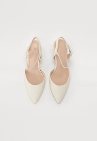Pekeflate slingback-sko i myk hvit skinn med en jevn tekstur, som har et enkelt justerbart stropp og minimalistisk design.