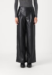 Pantaloni larghi in finta pelle nera con pieghe, vita alta e dettagli con bottoni. Texture liscia con finitura lucida.