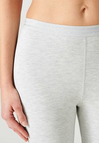 Leggings grigi chiari realizzati in un morbido e elastico tessuto con una texture liscia. Presentano un'ampia vita elastica con strisce sottili.