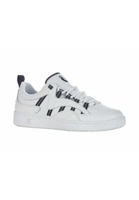 White sneakers with a textured surface, featuring black stripes, round toe, flat rubber sole, and a pull tab on the heel.