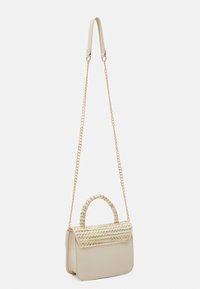 Borsa a mano beige strutturata con patta superiore intrecciata. Presenta una tracolla con catena dorata e una maniglia corta. Materiale liscio con accenti di struttura sottile.