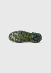 Footwear outsole in green-tinted rubber, featuring a textured pattern with grooves and rounded lugs for traction, branded with a number "55."