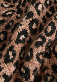 Material textil tricotat cu un model de imprimeu leopard în nuanțe de piersică și negru. Textura pare moale și pufos, cu pete negre distincte pe un fundal piersică.