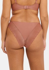 Ensemble de lingerie marron comprenant un soutien-gorge à coque lisse et des culottes taille haute texturées avec un panneau en dentelle géométrique au dos.