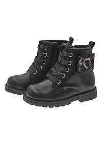Botas de tobillo de cuero negro con ojales metálicos, cordones brillantes, cremallera lateral y un acento decorativo con hebilla en forma de corazón.
