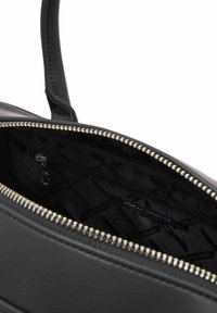 Borsa nera con zip argentata parzialmente aperta, che mostra l'interno foderato di nero con il logo Armani Exchange e una tasca interna con zip.
