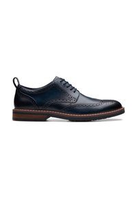 Navy leather dress shoe with brogue detailing, a rounded toe, and a contrasting light brown sole. Features laces and a pull tab.