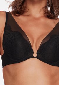 Schwarzer Spitzen-BH mit einem transparenten Mesh-Design, versehen mit einem tiefen V-Ausschnitt und markanten metallischen Details in der Mitte. Weiche, strukturierte Cups.