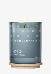 Skandinavische Kerze in einem durchscheinenden grauen Glaskontainer mit weißen geometrischen Mustern. Enthält einen Holzsockel und einen brennenden Docht.
